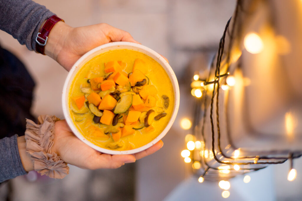 Hausgemachte Suppe vor weihnachtlicher Lichterkette