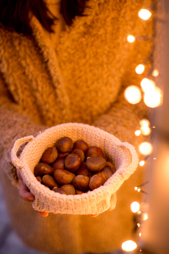 Marroni im Korb vor weihnachtlicher Lichterkette